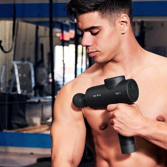 A young athlete using the opove M3 Pro Massage Gun on his shoulders - professional-grade percussion therapy device with deep tissue relief technology.