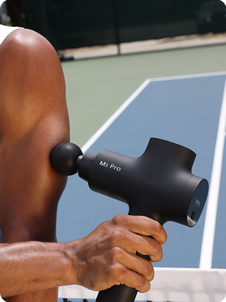 An athlete massages his arms with the Opove M3 Pro massage gun after a tennis match. The professional-grade percussion device delivers deep tissue relief to tired leg muscles