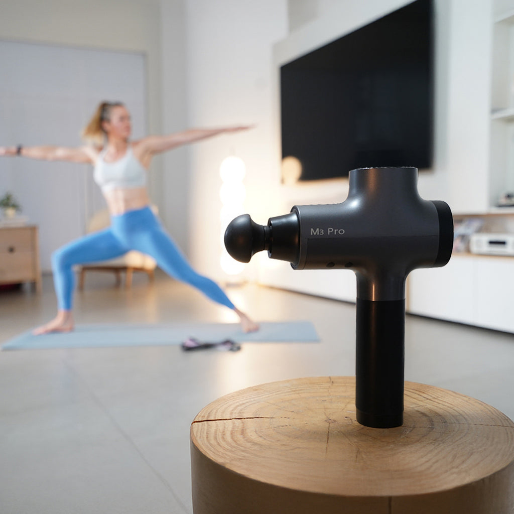 A woman prepares to use the opove M3 Pro massage gun for post-workout recovery at home. 